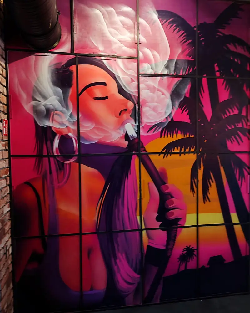 Portrait of a woman smoking shisha with an idyllic landscape in the background, painted on wood panels for a sisha bar in Giessen, Germany